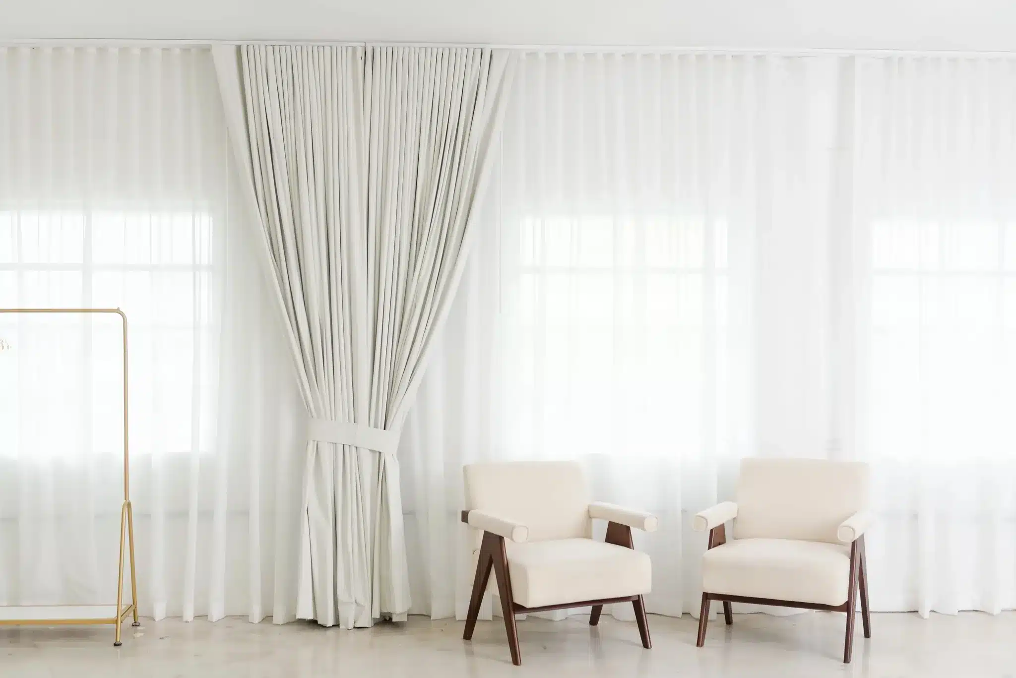 Cream armchairs against backlit sheer curtains in a sunlit Miami photo studio set | Creative Canvas Photo Studio Miami Cream armchairs against backlit sheer curtains in a sunlit Miami photo studio set
