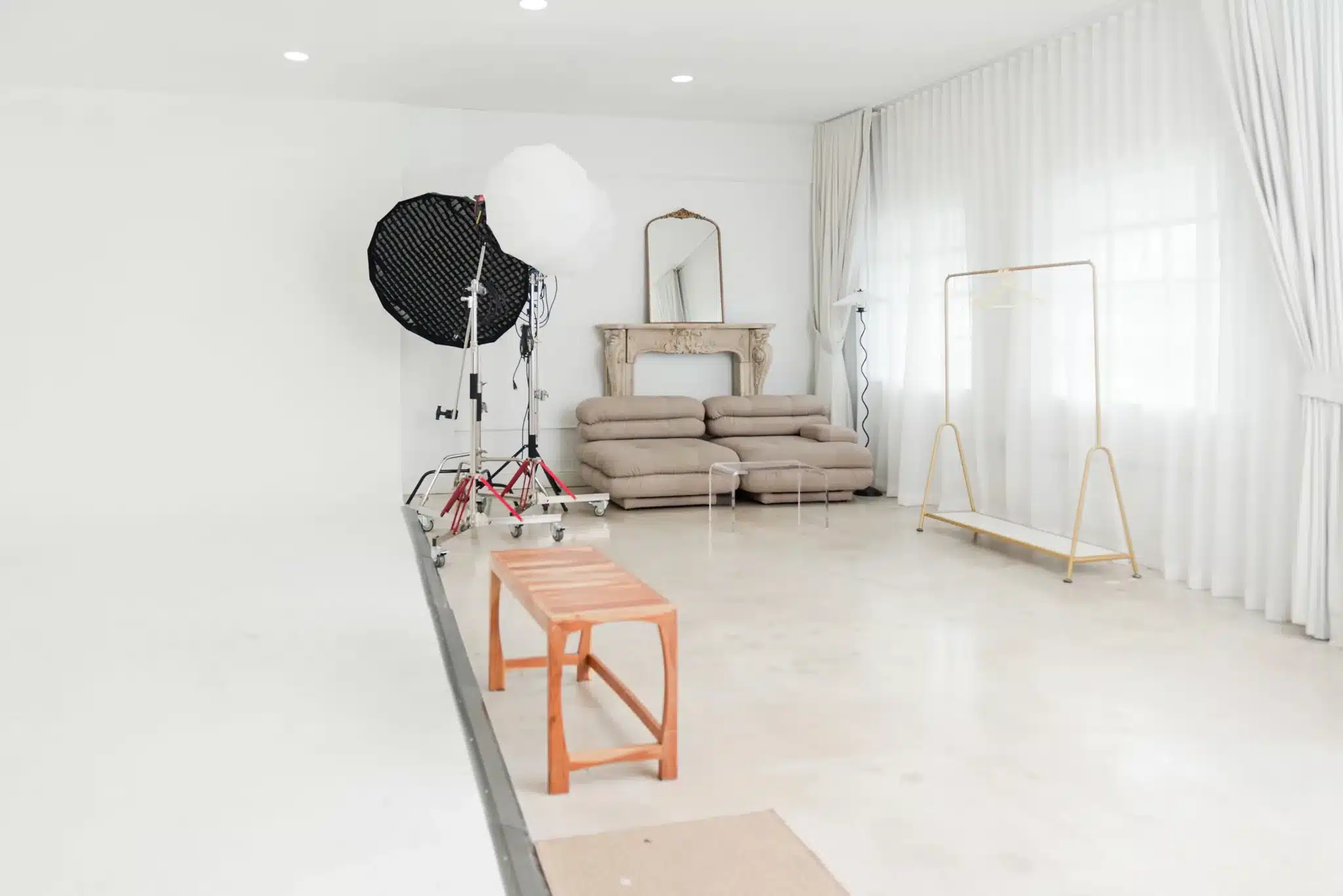 Taupe modular sofa lounge set with natural light and a gold garment rack in a Miami studio | Creative Canvas Photo Studio Miami Taupe modular sofa lounge set with natural light and a gold garment rack in a Miami studio