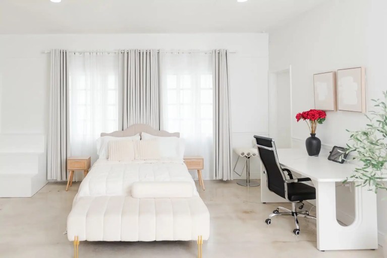 All-white bedroom set with a desk beside the bed