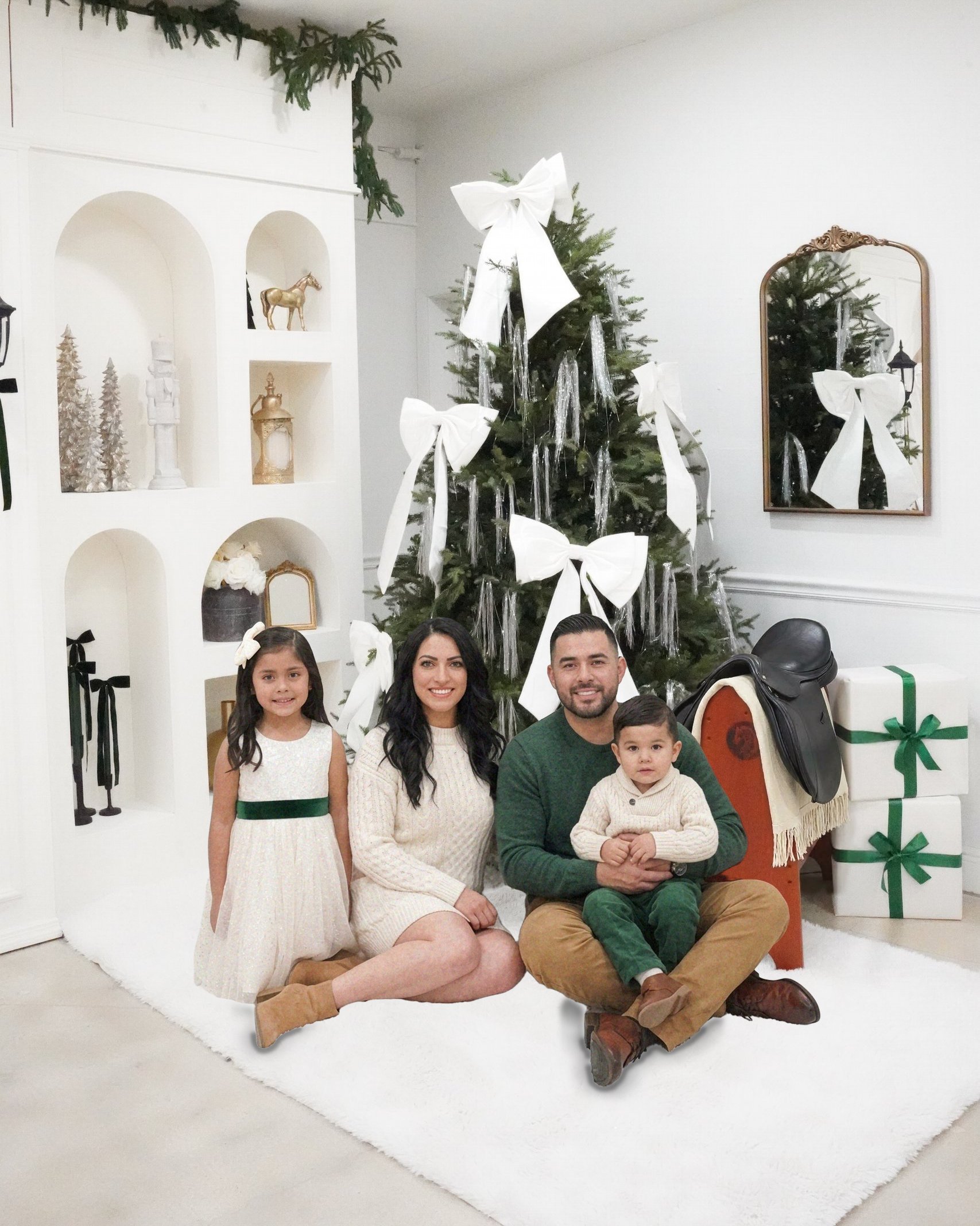Christmas photoshoot in Miami | Creative Canvas Photo Studio Miami Set de fotos navideñas en Miami familia de cuatro en una alfombra blanca bajo un árbol con lazos