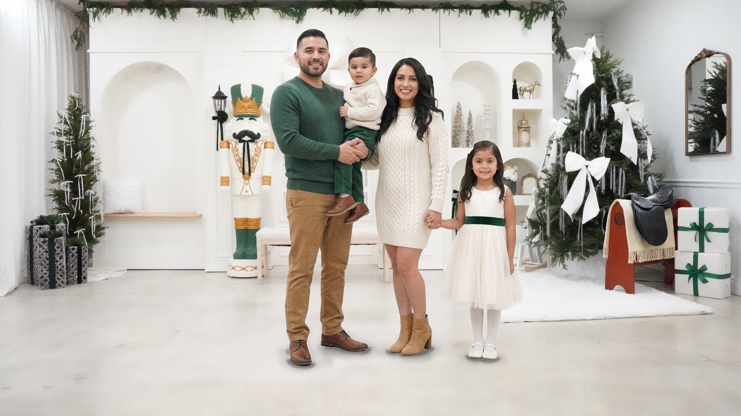 Christmas photoshoot in Miami | Creative Canvas Photo Studio Miami Set de fotos navideñas en Miami familia de cuatro junto al cascanueces y el árbol con lazos blancos