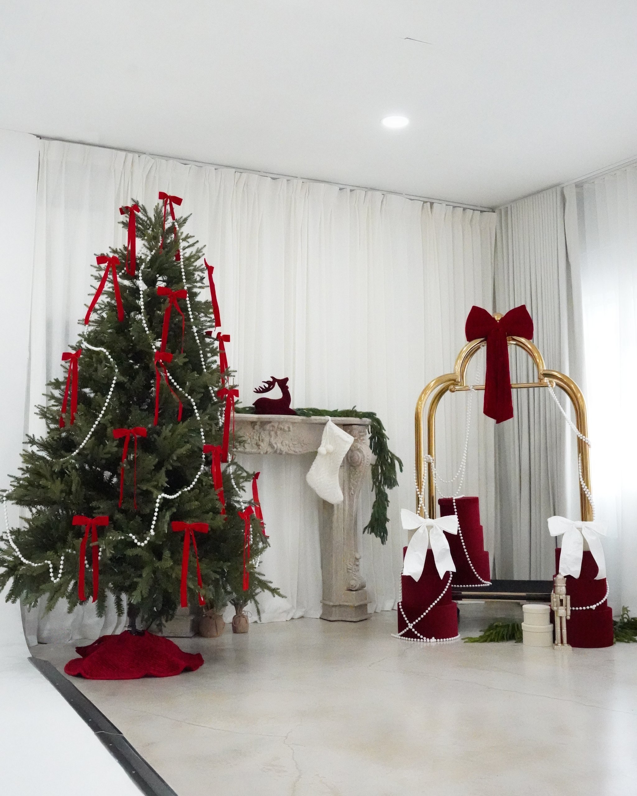 Christmas photoshoot studio in Miami | Creative Canvas Photo Studio Miami Set de fotos navideñas en Miami el set Grand Lobby con cortinas translúcidas en un estudio blanco