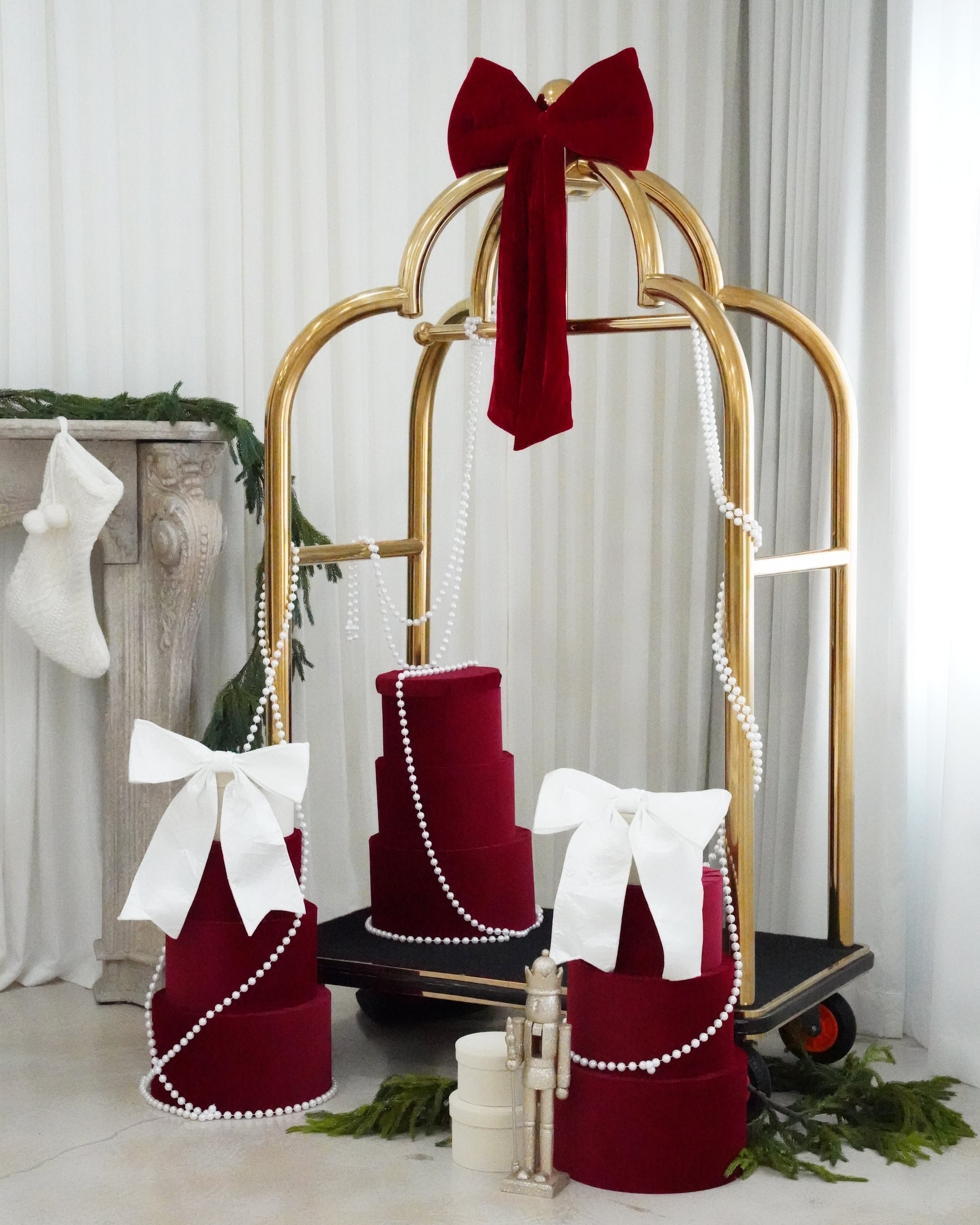 Christmas photoshoot studio in Miami | Creative Canvas Photo Studio Miami Set de fotos navideñas en Miami carrito dorado con regalos junto a una chimenea con guirnalda