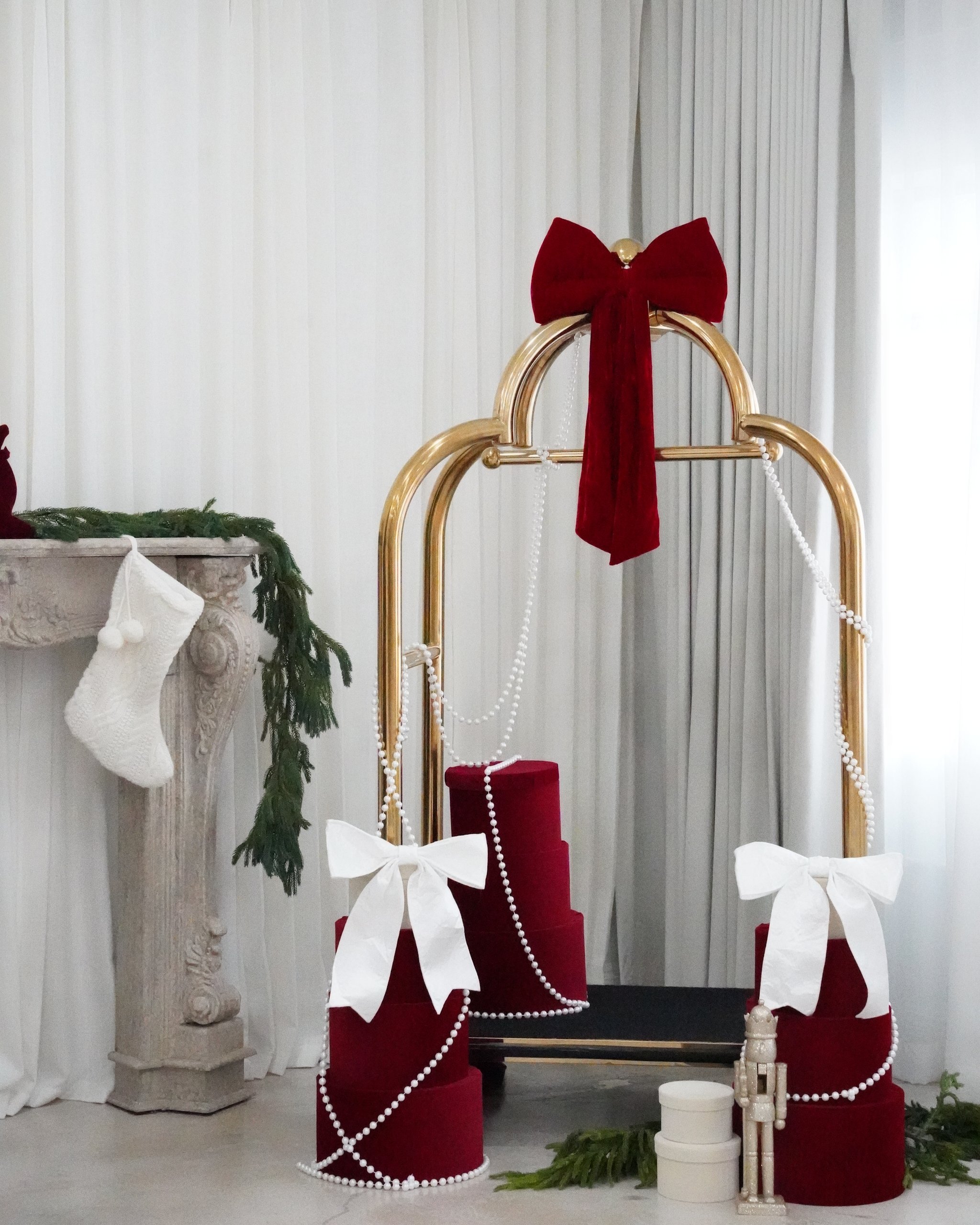 Christmas photoshoot studio in Miami | Creative Canvas Photo Studio Miami Set de fotos navideñas en Miami carrito dorado con regalos de terciopelo lazos blancos y perlas