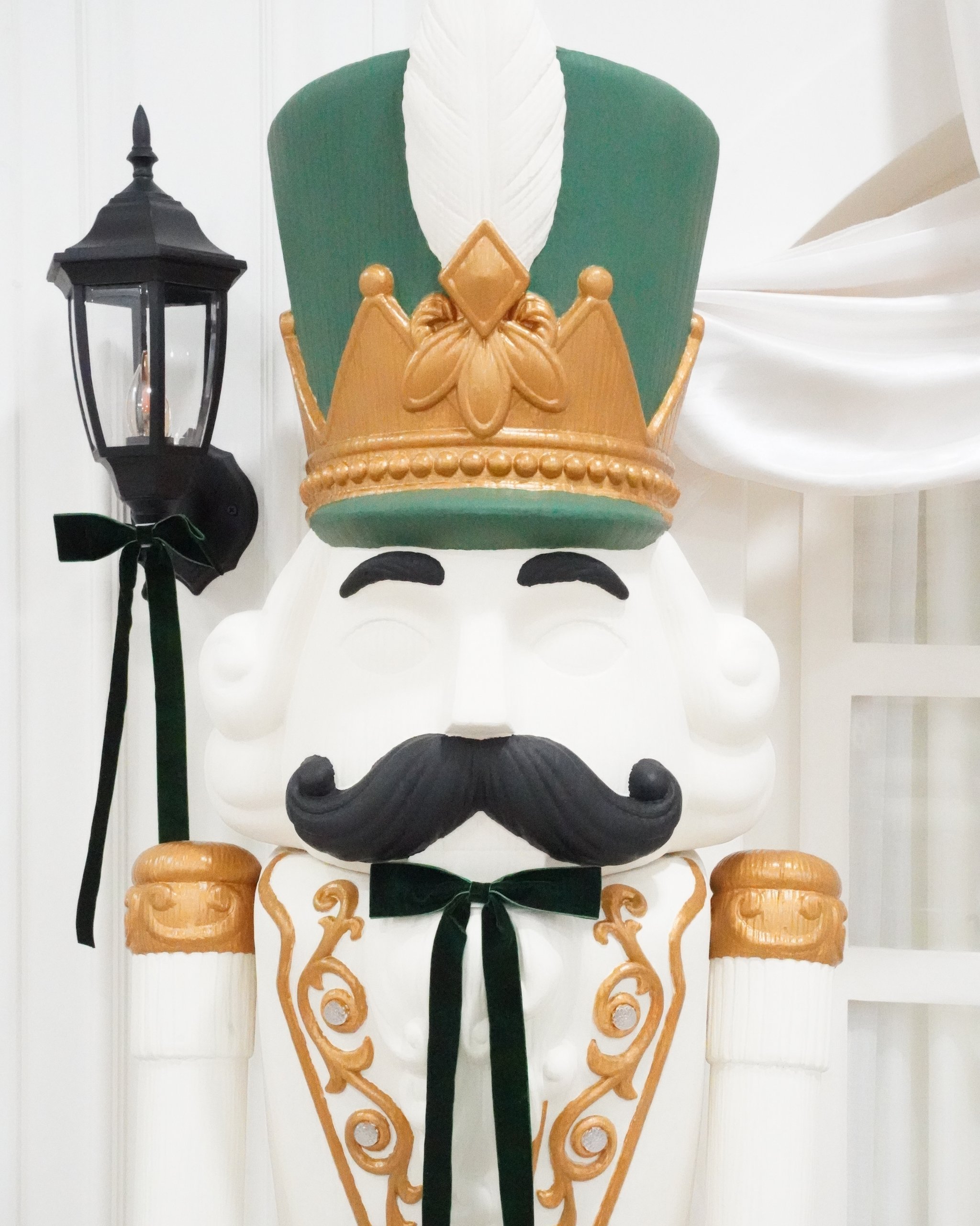 Christmas photo studio in Miami | Creative Canvas Photo Studio Miami Set de fotos navideñas en Miami cascanueces de tamaño real con sombrero verde y corona dorada
