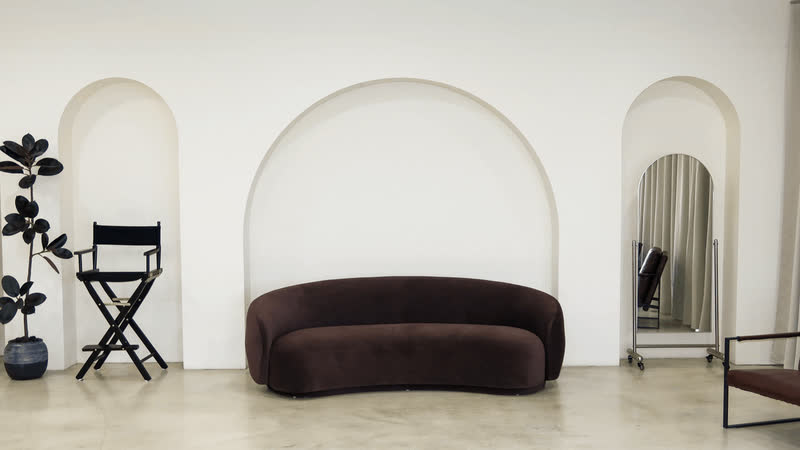 Three-arch wall with a curved brown sofa and a director's chair in a Miami photo studio