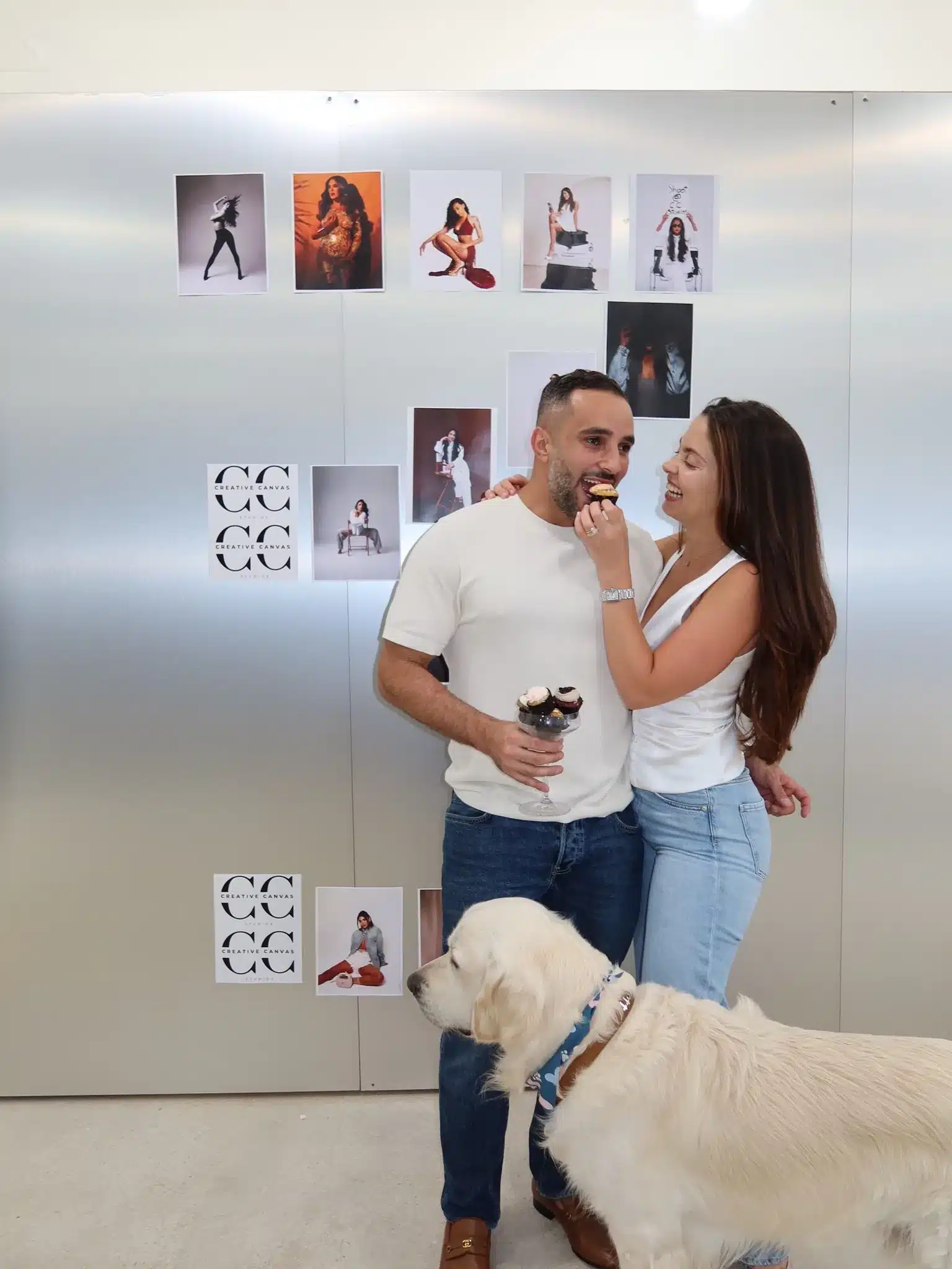 Couples Photoshoot Miami Photo Studio | Cupcakes and Dog | Creative Canvas Photo Studio Miami Sesión de fotos en pareja en Miami mujer dándole un cupcake a su pareja junto a su golden retriever en un set plateado